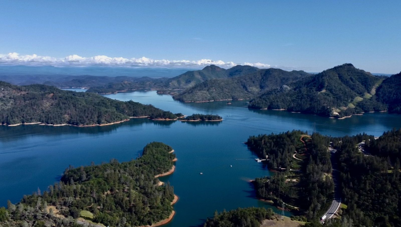 Mountain lake with forested shoreline aerial
